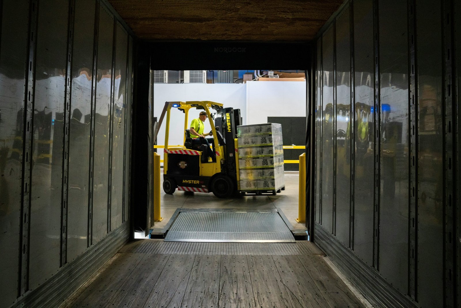 man carrying box using fork liftr